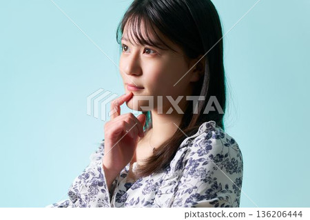 一位二十多歲的日本女性,手托著下巴,若有所思。 一位二十多歲的日本女性,手托著下巴,若有所思。 136206444