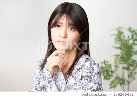 A Japanese woman in her twenties looking up and thinking A Japanese woman in her twenties looking up and thinking 136206451