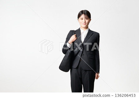 A woman looking for work wearing a suit and carrying a bag 136206453