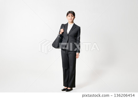 一位身穿套裝、手提包的女士正在尋找工作。 136206454