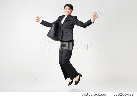 一位身穿應徵入伍服的日本女子高興地跳了起來 一位身穿應徵入伍服的日本女子高興地跳了起來 136206458