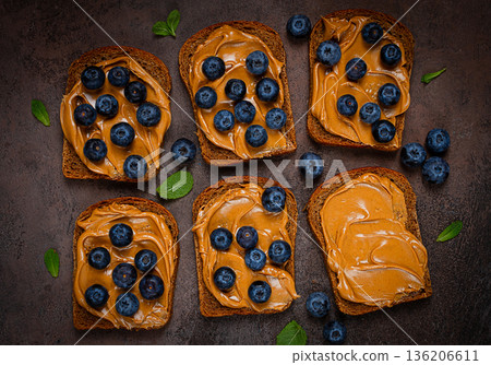 rye bread with peanut paste and fresh blueberries, top view, no people, 136206611