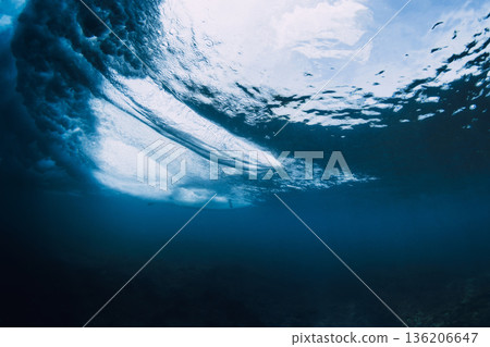 Surfer riding with surfboard, breaking ocean wave 136206647