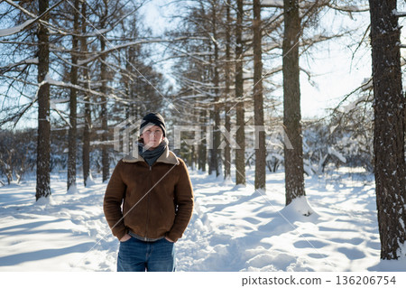 Man standing in snowy park in winter Man standing in snowy park in winter 136206754