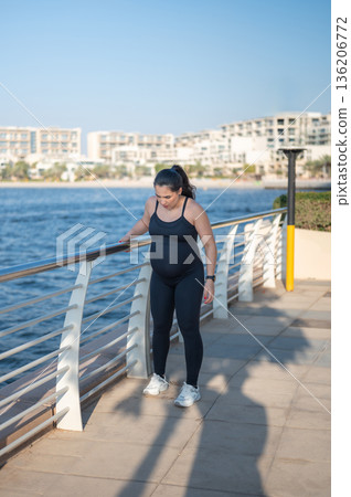 Pregnant Woman Exercising With Focus By The Waterway On A Sunny Day 136206772