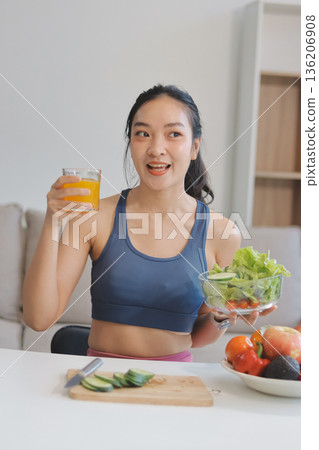 Fit young Asian women in activewear sitting on yoga mat and eating fresh vegetable salad after workout, representing clean eating, fitness lifestyle, wellness routine and health balance. Fit young Asian women in activewear sitting on yoga mat and eating fresh vegetable salad after workout, representing clean eating, fitness lifestyle, wellness routine and health balance. 136206908