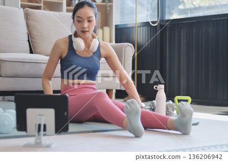 Young Asian sporty attractive people practicing yoga lesson with instructor. Asia group of women exercising healthy lifestyle in fitness studio. Sport activity, gymnastics or ballet dancing class. 136206942