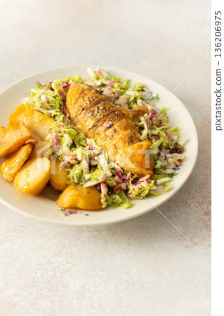 Fresh baked potatoes and chicken breast served with a salad of Chinese cabbage and pink radish make a healthy breakfast option. This meal is prepared at home and offers nutrition Fresh baked potatoes and chicken breast served with a salad of Chinese cabbage and pink radish make a healthy breakfast option. This meal is prepared at home and offers nutrition 136206975