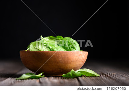 Bright green spinach leaves in wooden bowl Bright green spinach leaves in wooden bowl 136207060