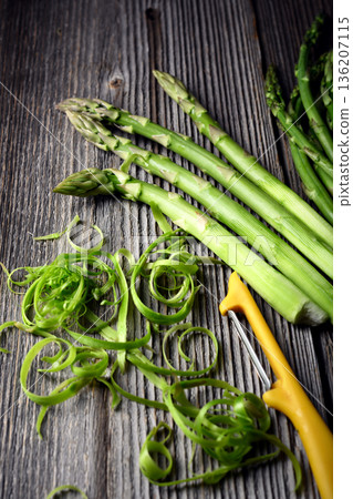Fresh green asparagus arranged with yellow peeler 136207115