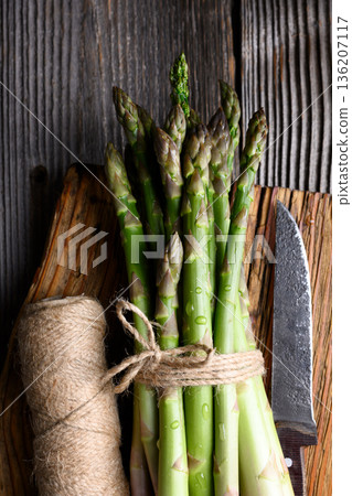 Fresh green asparagus bundle arranged with twine and knife Fresh green asparagus bundle arranged with twine and knife 136207117