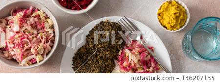A well-balanced, wholesome breakfast made with quinoa pancakes, fresh greens, radishes, mung bean sprouts, eggs, hummus, and beets, offering protein, fiber, and energy, banner 136207135