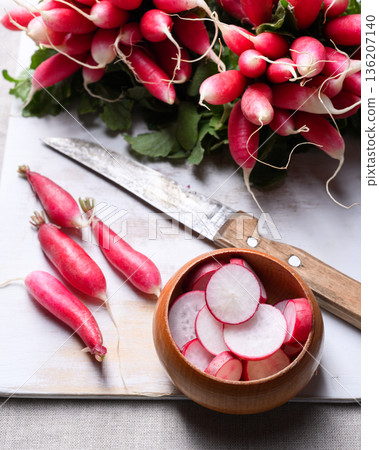 Fresh radish bunch and sliced pieces in wooden bowl Fresh radish bunch and sliced pieces in wooden bowl 136207140