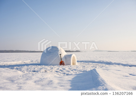 Igloo with snow shovel on the winter field 136207166