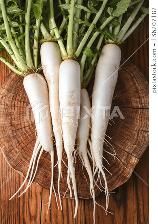 Raw daikon radish arranged on wooden cutting board Raw daikon radish arranged on wooden cutting board 136207182