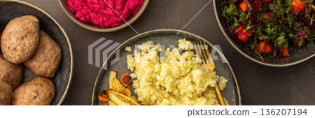 Delight in a flavorful vegetarian lunch or breakfast with millet, roasted zucchini and carrots, a fresh salad with seasonal vegetables and herbs, plus chickpea buns and beetroot hummus, banner 136207194