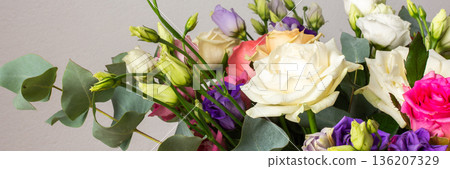 This seasonal bouquet of roses, eucalyptus, and eustoma in soft pink, white, and purple tones makes an ideal gift for anniversaries, birthdays, or any special event, banner 136207329