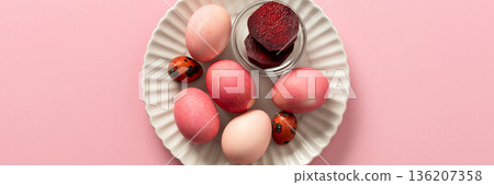 A variety of dyed Easter eggs in soft pink and vibrant shades rest on a decorative plate, a small bowl of beets, a way to dye eggs pink, ready for an Easter celebration filled with joy, banner A variety of dyed Easter eggs in soft pink and vibrant shades rest on a decorative plate, a small bowl of beets, a way to dye eggs pink, ready for an Easter celebration filled with joy, banner 136207358