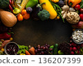 Fresh vegetables and fruits fill a surface after being gathered from the garden, showcasing a variety of colors and shapes during the harvest time in autumn 136207399