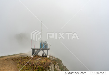 Industrial gas cylinders and technical equipment for anti avalanche installation on mountain ridge in heavy fog copy space Industrial gas cylinders and technical equipment for anti avalanche installation on mountain ridge in heavy fog copy space 136207545