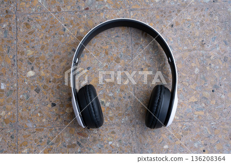 White wireless headphones on a red granite surface 136208364