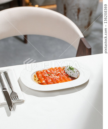 Salmon slices with creamy sauce and herbs 136208369