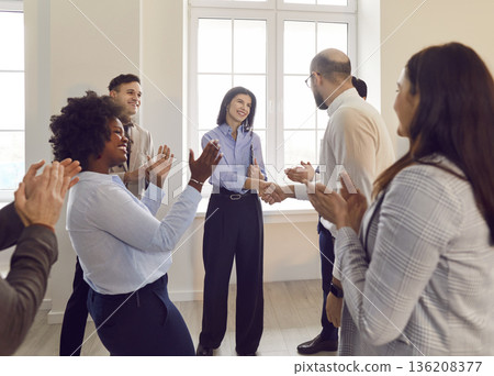 Happy colleagues shaking hands at meeting in office, celebrating success or business achievement. 136208377