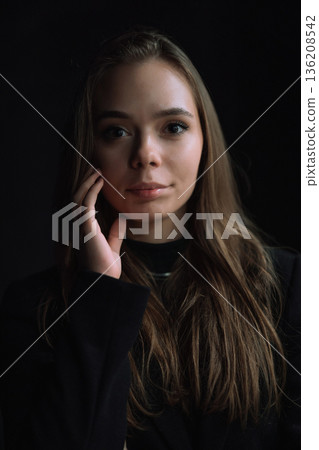 Intimate Low Key Portrait of Young Woman Touching Face with Soft Natural Window Light and Deep Shadows Creating Emotional Cinematic Mood Intimate Low Key Portrait of Young Woman Touching Face with Soft Natural Window Light and Deep Shadows Creating Emotional Cinematic Mood 136208542