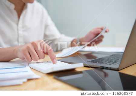 Businessman hands or finance with calculator or documents for project budget or expenses in office. Man, accountant or tax collector with laptop for financial analysis, bills or audit Businessman hands or finance with calculator or documents for project budget or expenses in office. Man, accountant or tax collector with laptop for financial analysis, bills or audit 136208577
