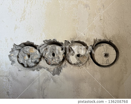 Wall with circular holes for electrical wiring installation in renovation project background 136208768