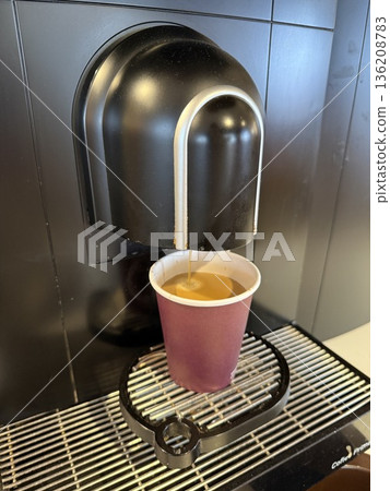 Espresso machine making coffee in disposable cup on black table background from top view Espresso machine making coffee in disposable cup on black table background from top view 136208783