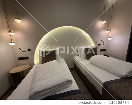 Modern hotel room interior with twin beds, ambient lighting, and cozy decor, ideal for relaxation 136208784
