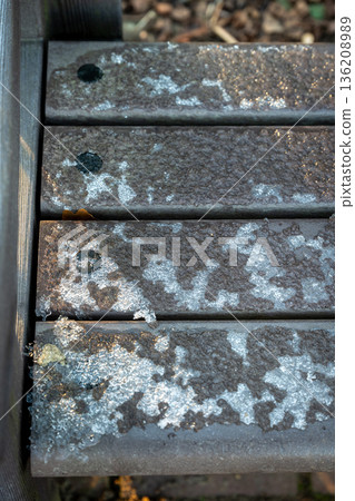 Icy park bench in winter 136208989