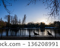Lake in Kelsey Park, a public park in Beckenham, Kent, UK. View at sunset with two pigeons silhouetted against the water. 136208991