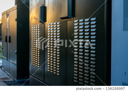 Electrical supply boxes near a road in Beckenham, Kent, UK. Late afternoon sunlight illuminates the details. 136208997
