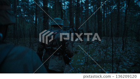 Wehrmacht soldiers patrolling forest at night during WWII 136209120