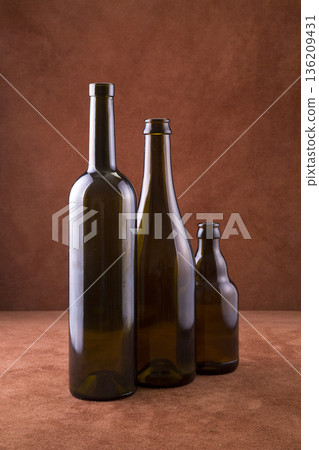Still life with bottles on a table with a brown background Still life with bottles on a table with a brown background 136209431
