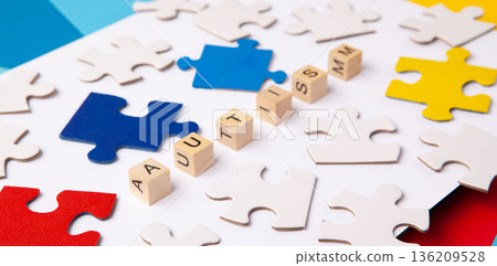 Autism Awareness Day design with colorful and white puzzle pieces on blue background, simple symbolic layout. support and understanding, top view, space for text. Autism Awareness Day design with colorful and white puzzle pieces on blue background, simple symbolic layout. support and understanding, top view, space for text. 136209528