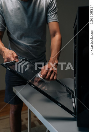 Vertical cropped shot of computer technician wiping glass panel, clearing dust buildup and improving internal airflow for enhanced electronic system performance. Concept of service, cleaning PC. Vertical cropped shot of computer technician wiping glass panel, clearing dust buildup and improving internal airflow for enhanced electronic system performance. Concept of service, cleaning PC. 136209534