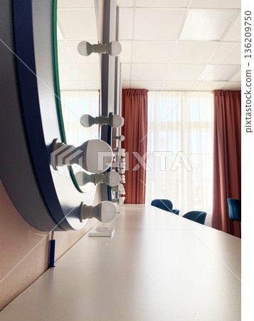 Modern vanity mirror with bright bulbs reflecting natural light, showcasing elegant design elements and a stylish atmosphere in a contemporary interior space 136209750