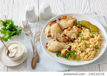 Boneless chicken thighs and couscous on a plate 136210156