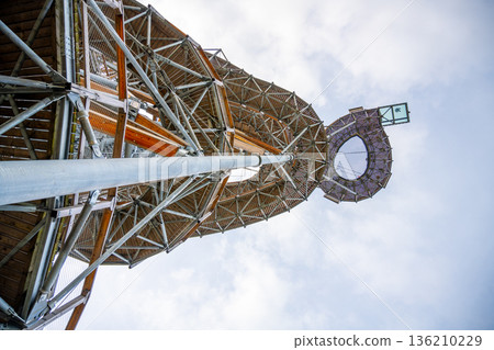 People visit a tall tower structure with a viewing platform at the top. The tower stands high against a cloudy sky. Visitors enjoy the view from the surrounding area. People visit a tall tower structure with a viewing platform at the top. The tower stands high against a cloudy sky. Visitors enjoy the view from the surrounding area. 136210229