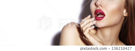 Elegant Model Presenting Vibrant Lips. Fashionable Woman Emphasizing Striking Red Lipstick. Luxurious Fashion Image Featuring Model Showcasing Bold Red Lips And Glossy Nails Under Studio Lighting 136210427