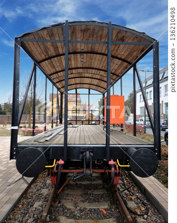 A restored wooden railway platform car on the tracks 136210498