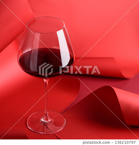 Red Wine Glass on Sculptural Red Background. Elegant Monochrome Still Life Red Wine Glass on Sculptural Red Background. Elegant Monochrome Still Life 136210797