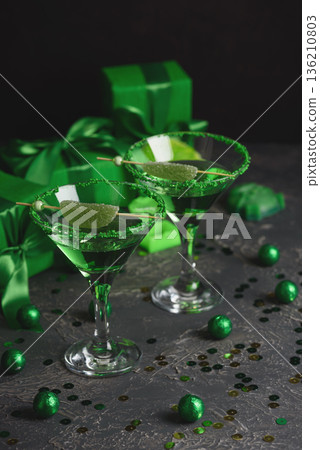 Green Cocktails with Lime, Gifts and Confetti. Festive St. Patricks Day Celebration Still Life Green Cocktails with Lime, Gifts and Confetti. Festive St. Patricks Day Celebration Still Life 136210803