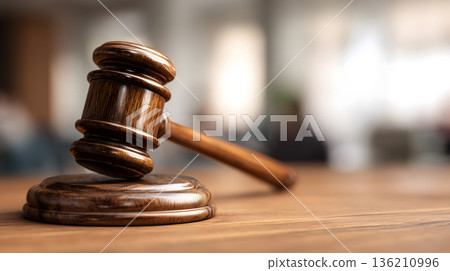Wooden gavel sits on a wooden base. The gavel is brown and has a wooden handle Wooden gavel sits on a wooden base. The gavel is brown and has a wooden handle 136210996