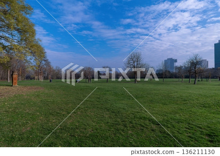 Wide green lawn in Donaupark Vienna with trees and modern skyline. Vienna, Austria Wide green lawn in Donaupark Vienna with trees and modern skyline. Vienna, Austria 136211130