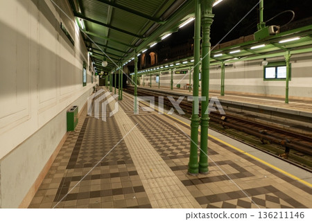 Empty Vienna metro platform at night with green columns and canopy. Vienna, Austria Empty Vienna metro platform at night with green columns and canopy. Vienna, Austria 136211146