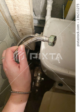 Old toilet in a dilapidated house with visible plumbing issues, showcasing the need for extensive renovations and repairs in a neglected bathroom environment 136211273